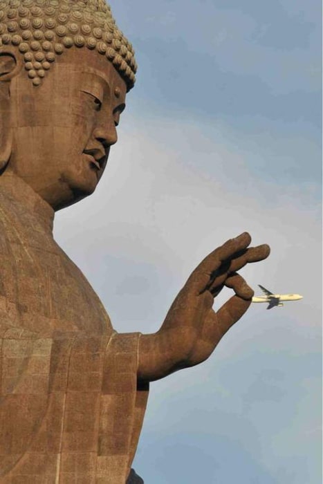 Foto de una estatua de Buda que parece sostener un avión