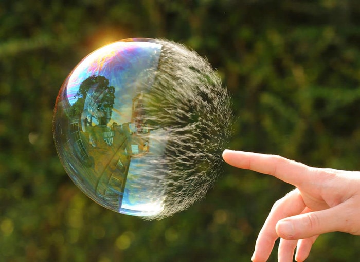 Una persona tocando una gran burbuja.