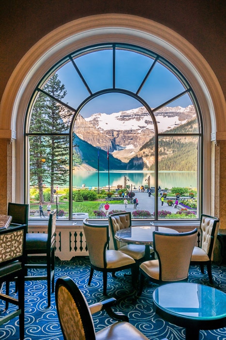 Un impresionante paisaje montañoso filmado a través de una gran ventana de vidrio con el interior del restaurante en primer plano: ventana de cómo ganar dinero con la fotografía de viajes