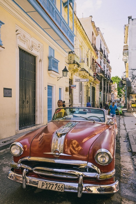 Un auto rojo estacionado en una calle de Cuba - como ganar dinero con la fotografía