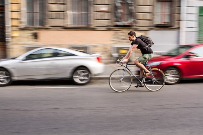 Un ciclista en la calle con desenfoque de movimiento en el fondo