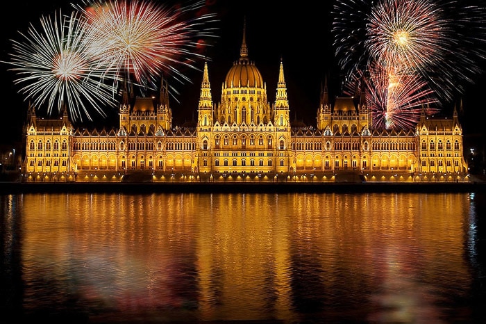 Impresionante fotografía de fuegos artificiales de múltiples explosiones grandes sobre el edificio del parlamento de Budapest