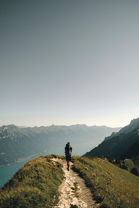 Una persona de pie al borde de una montaña.