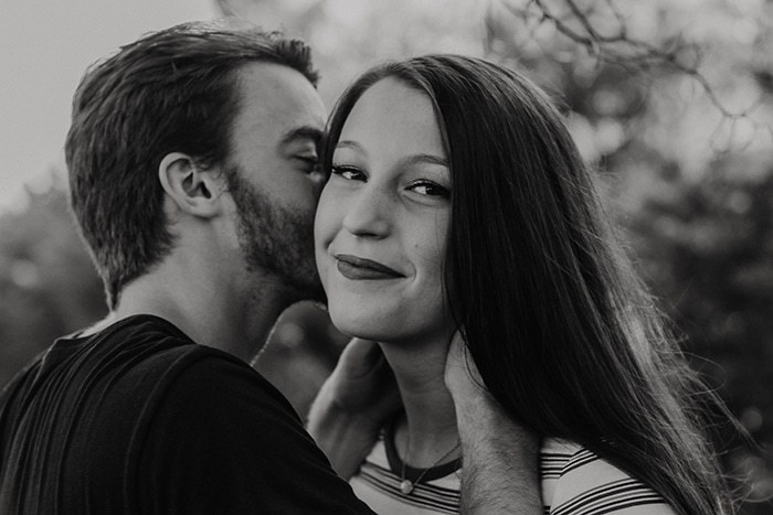 retrato en blanco y negro de un hombre besando a su novia sonriente