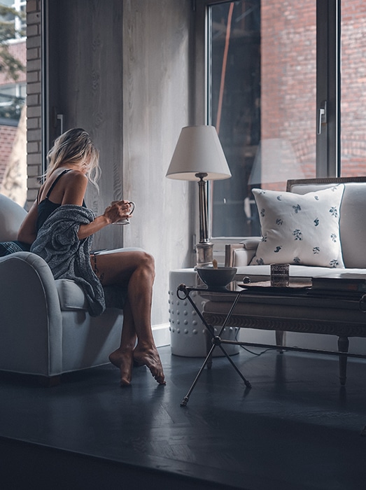 Chica rubia tomando café en una sala de estar