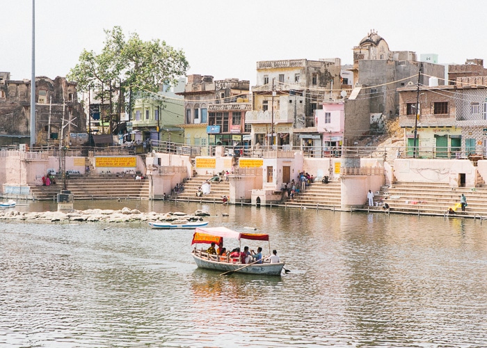 Un barco en un río pasando por coloridos edificios en la India
