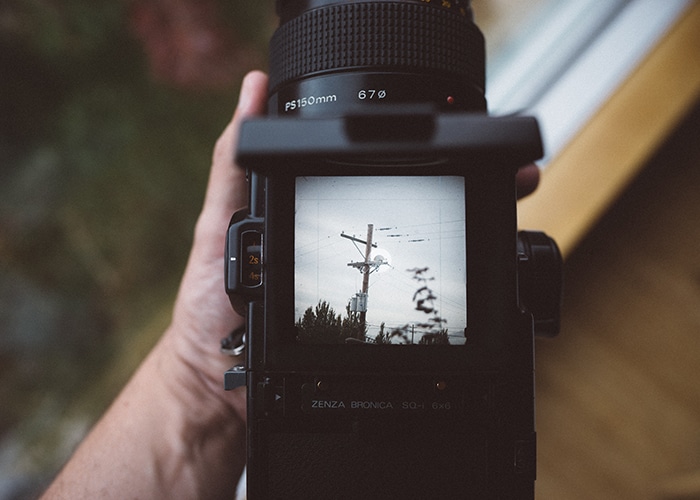 Un fotógrafo sosteniendo una cámara de película antigua de zenza bronica