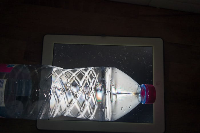 Una botella de bebida PET frente a la pantalla de un portátil