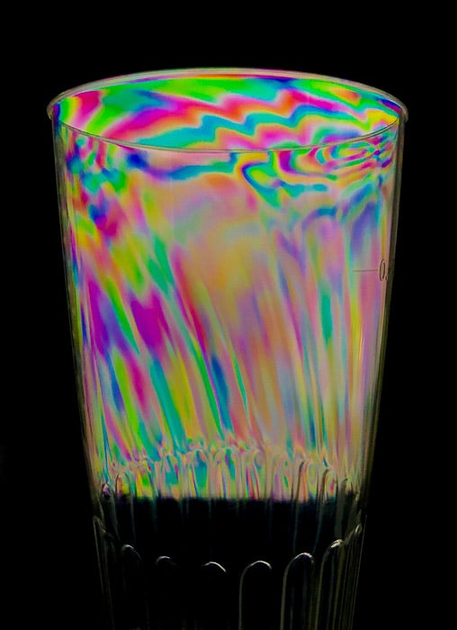 Efecto de fotoelasticidad en vaso de plástico transparente.