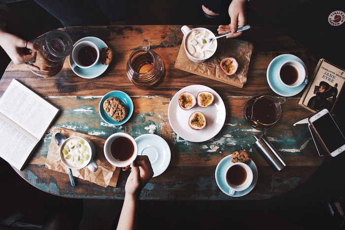 Tazas de café y comida sobre una mesa de madera