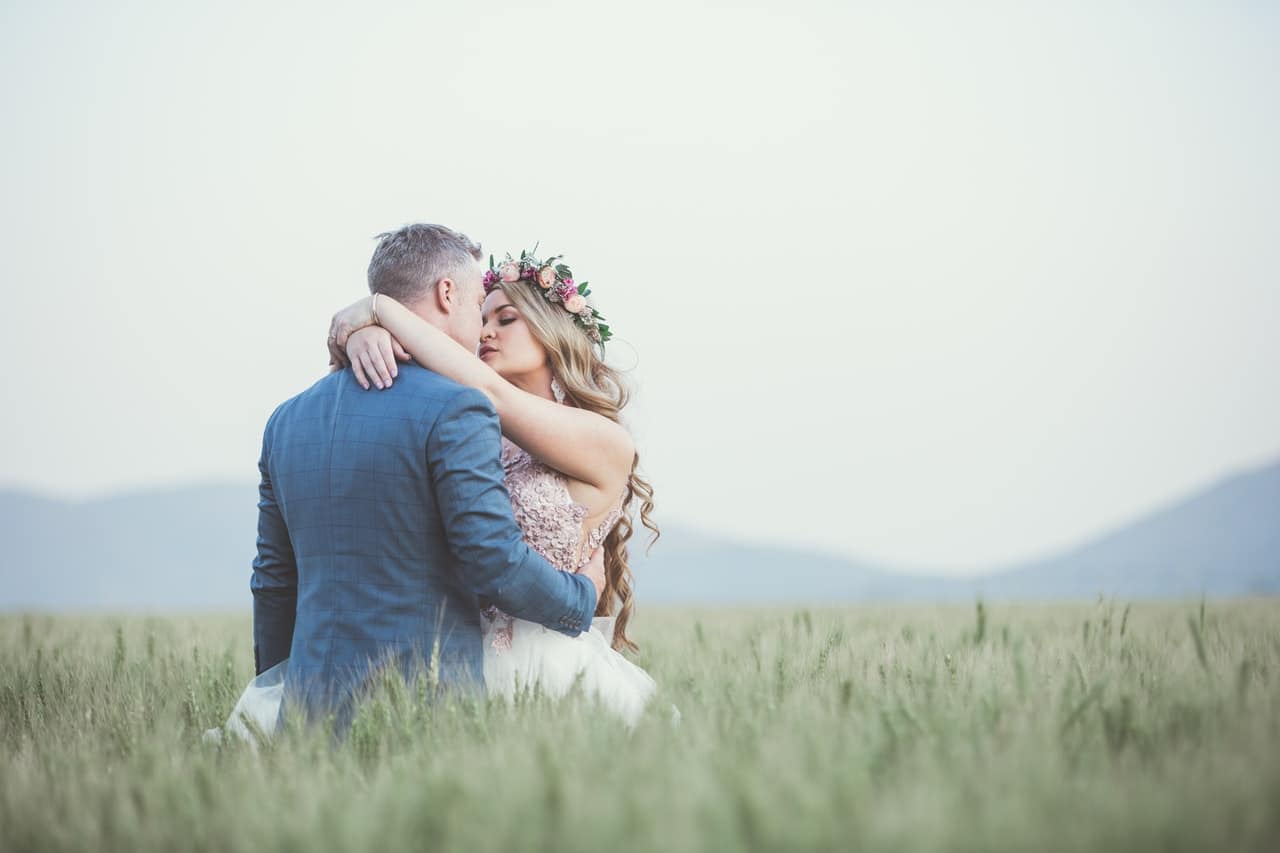 Una fotografía de boda de una novia y un novio en un campo