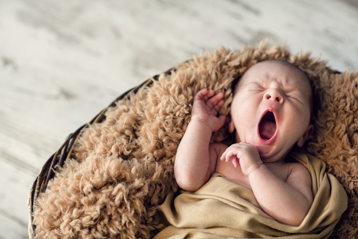 Dulce retrato de un bebé recién nacido bostezando