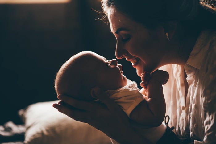 Un retrato de una madre sosteniendo a un bebé recién nacido