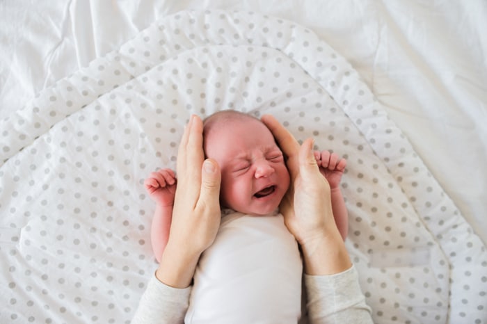 Dulce retrato de un bebé recién nacido retenido por un padre