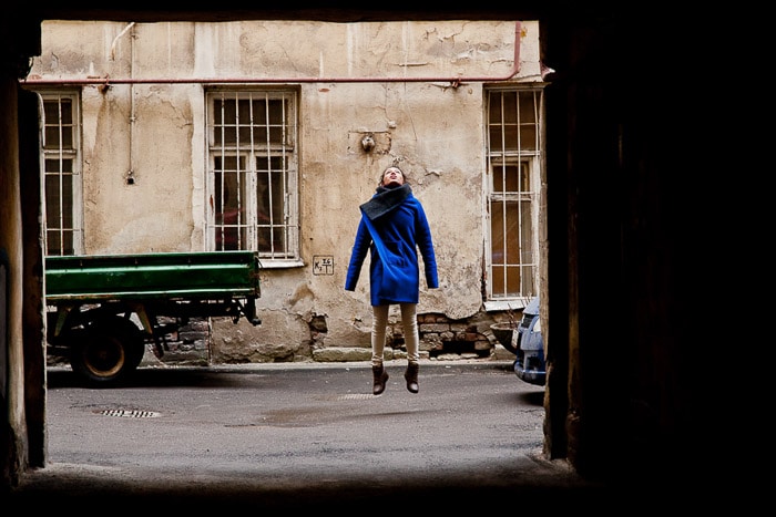 Una fotografía de luz natural retrato de una niña saltando en los patios de San Petersburgo