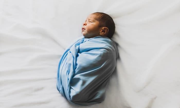 foto de un recién nacido en una pequeña manta azul