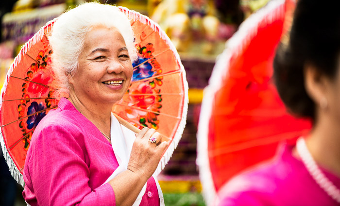 Un colorido retrato callejero de una elegante mujer mayor que sostiene un paraguas: consejos sobre el uso de fotografías que cuentan una historia