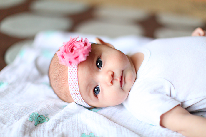 Bebé con una diadema rosa.