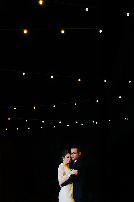 Retrato de los recién casados ​​bailando en una boda al aire libre por la noche