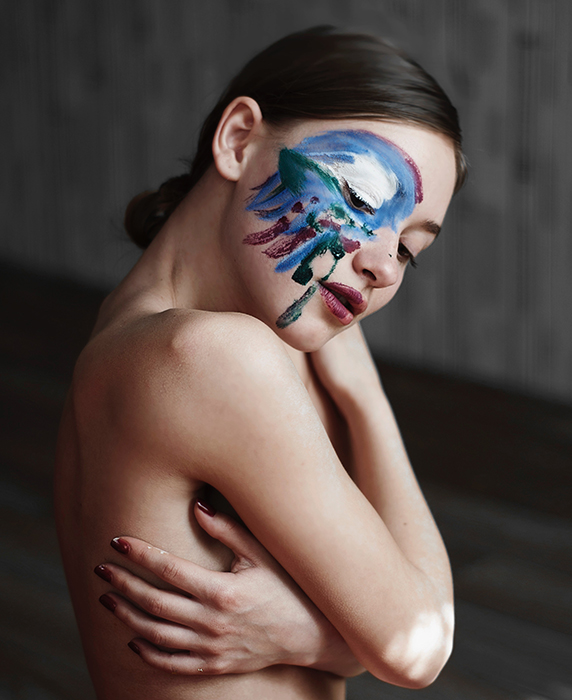 Fotografía de desnudo artístico de un modelo femenino con pintura en su rostro