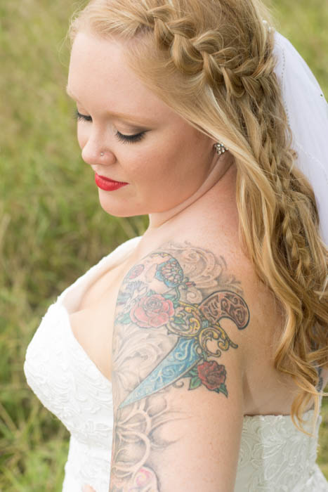Un retrato de una novia tatuada posando al aire libre