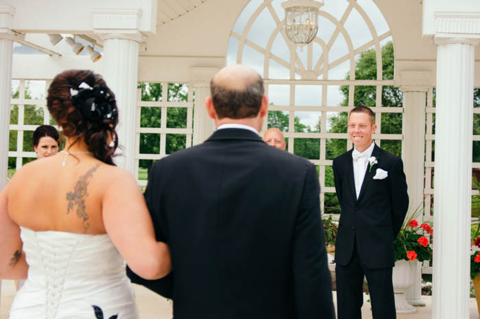 fotografía de boda de la novia y el padre de la novia caminando por el pasillo