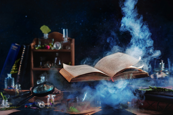 Libro mágico volador con humo - naturaleza muerta con colores que contrastan con el azul