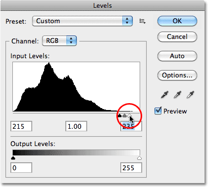 Arrastrando el control deslizante blanco en las opciones de Niveles en el Panel de Ajustes en Photoshop CS5.