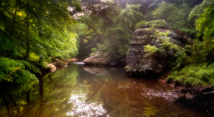 Foto de un pequeño lago en un bosque con efecto orton