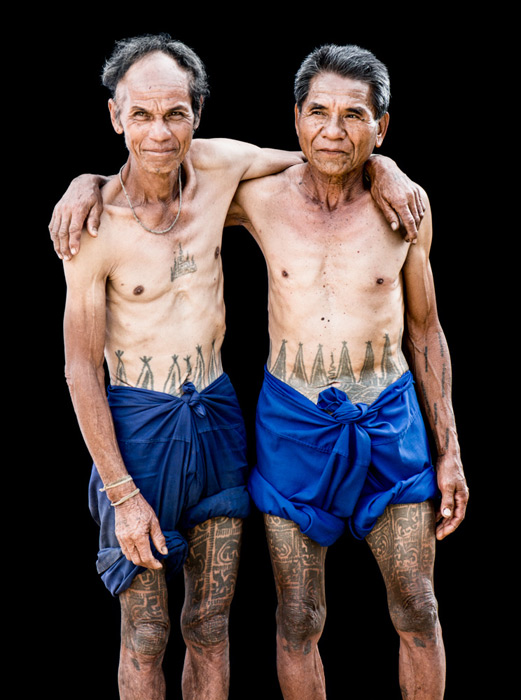 Una foto de estudio de fotografía de retrato al aire libre de dos hombres Karen con sus tatuajes tradicionales.