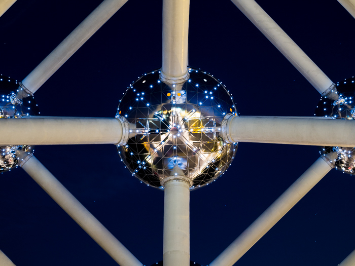 Cerrar detalle de una parte del Atomium, luces de la ciudad que se reflejan en la esfera