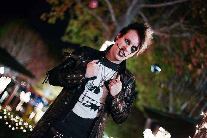 Un modelo masculino con ropa gótica posando para una fotografía de retrato nocturno