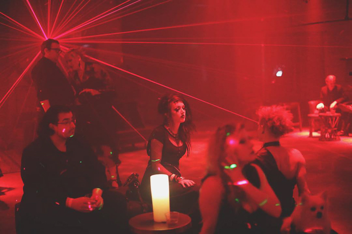 Retrato de club nocturno atmosférico de asistentes a la fiesta sentados y charlando