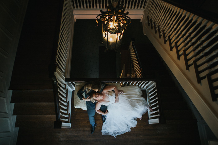 un retrato aéreo de una pareja de recién casados ​​posando en una escalera