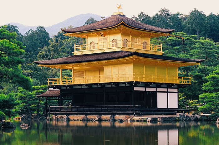 El templo cubierto de oro de Kinkakuji en Kioto, junto a un bosque y un estanque.  Consejos de fotografía de Japón 