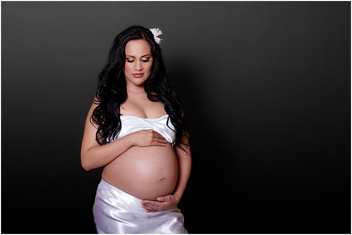 Un dulce retrato de maternidad de una mujer embarazada tomada en un estudio fotográfico portátil