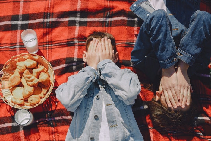 Fotografía cenital de niños juguetones en una manta para picnic