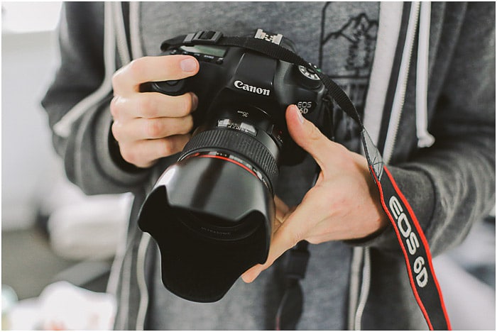 un fotógrafo de retratos profesional con una cámara réflex digital Canon - precios de fotografía de retrato