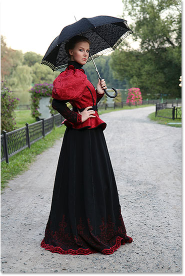 Chica con un paraguas en un traje vintage en un parque.  Imagen con licencia de Shutterstock de Photoshop Essentials.com.  No debe usarse sin permiso.