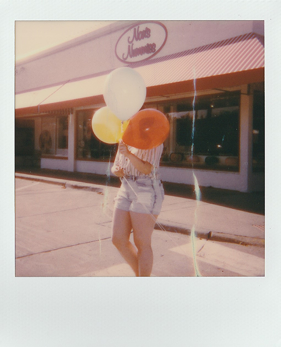 Foto Polaroid de una mujer con globos en sus manos