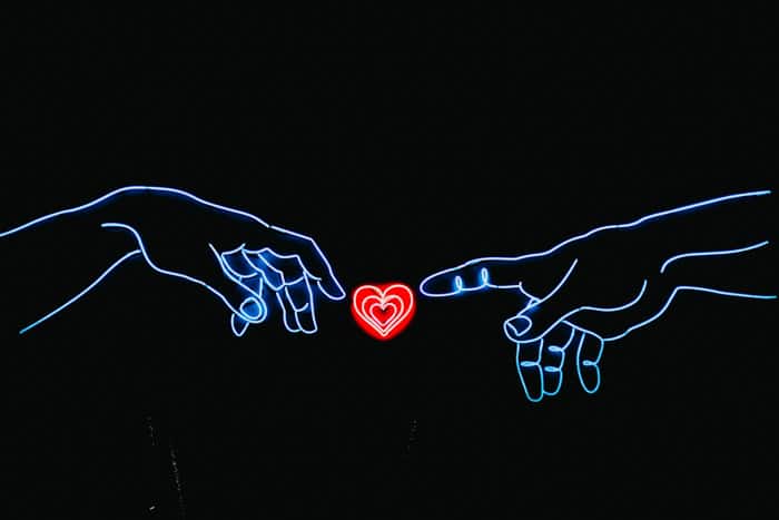 Un letrero de neón de dos manos apuntando a un corazón de amor rojo: las mejores ideas de logotipos de fotografía