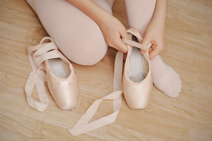 primer plano de una niña poniéndose sus zapatillas de ballet - accesorios fotográficos