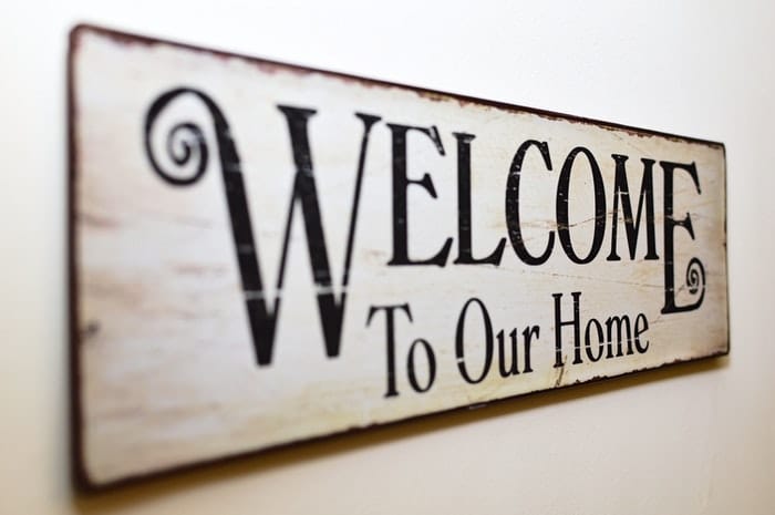 Un cartel de madera que dice "Bienvenidos a nuestra casa".