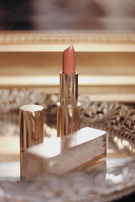 Una foto de producto de maquillaje elegante de Becca Lipstick en una bandeja de lujo