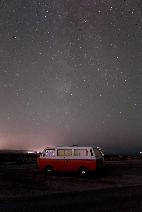 caravana roja y blanca bajo el cielo estrellado astrofotografía
