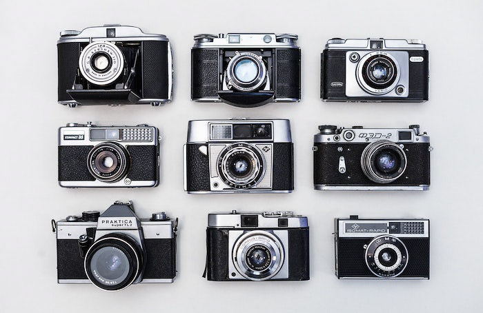 Un plano de nueve cámaras de película antiguas sobre un fondo blanco - sesión de fotos profesional
