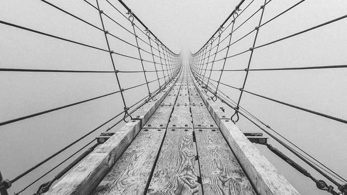 Una fotografía en blanco y negro de un puente que demuestra el uso del principio del arte y el diseño en la fotografía.