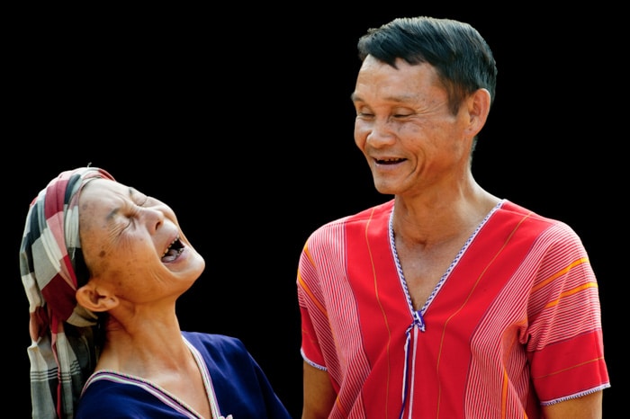 Un retrato de una pareja de Pwo Karen riendo contra un fondo negro portarit - errores de iluminación de fotografía