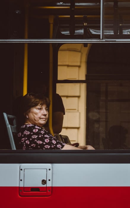 Una mujer sentada en la ventana de un autobús.