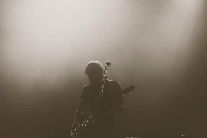 Fotografía de concierto atmosférico de un guitarrista en el escenario